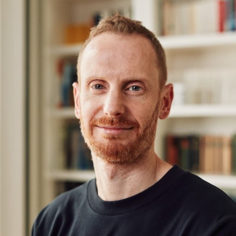 Phil Burton smiling in a black-and-white portrait.